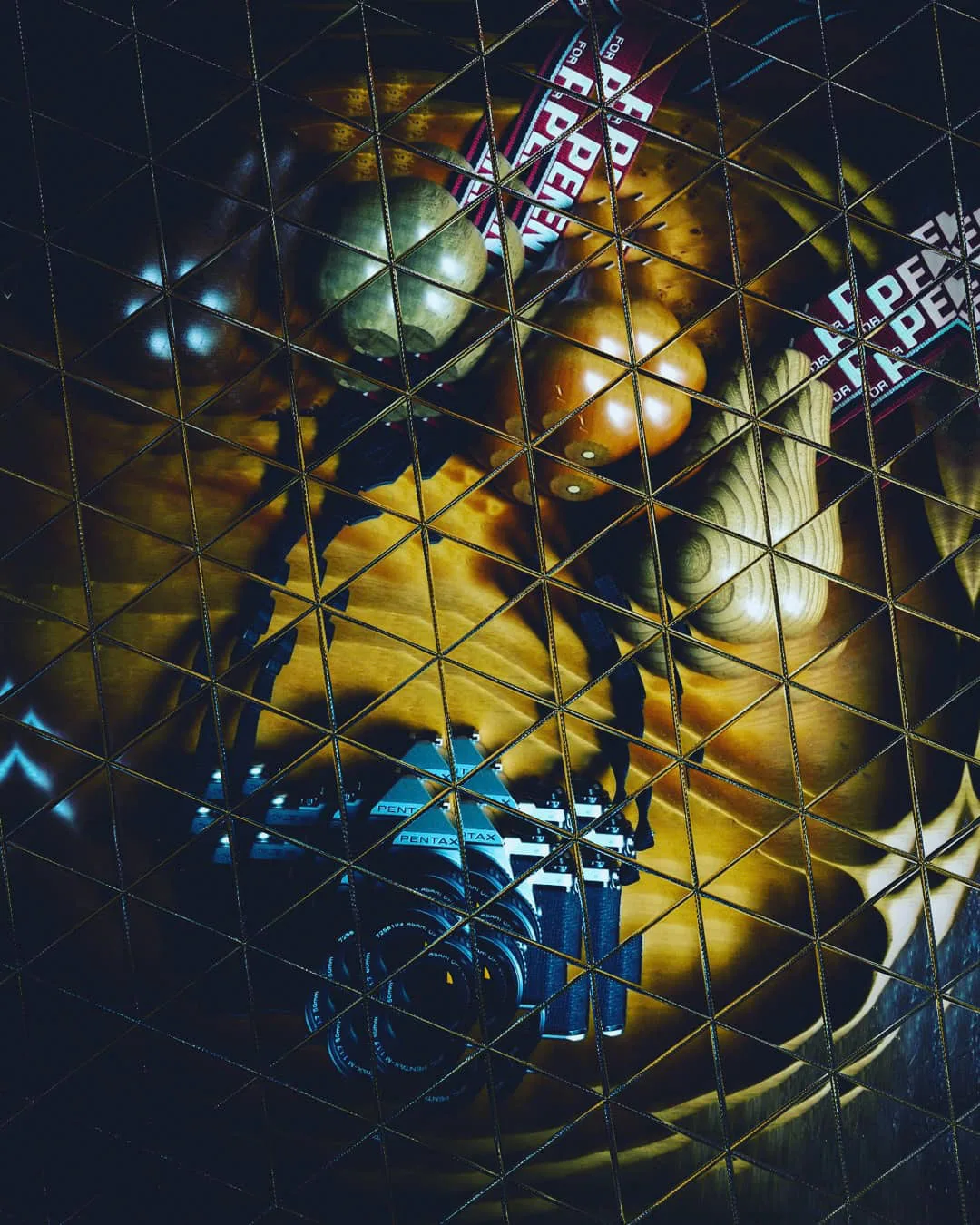 Abstract dark artwork with gold shapes behind a triangular grid