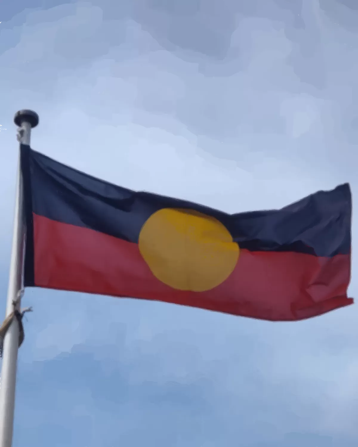 Aboriginal flag flying against a pale sky
